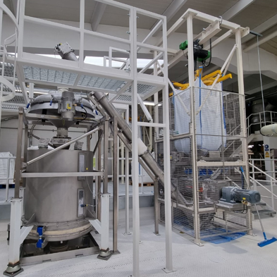 Big bag discharger and screw feeder to deck sieve